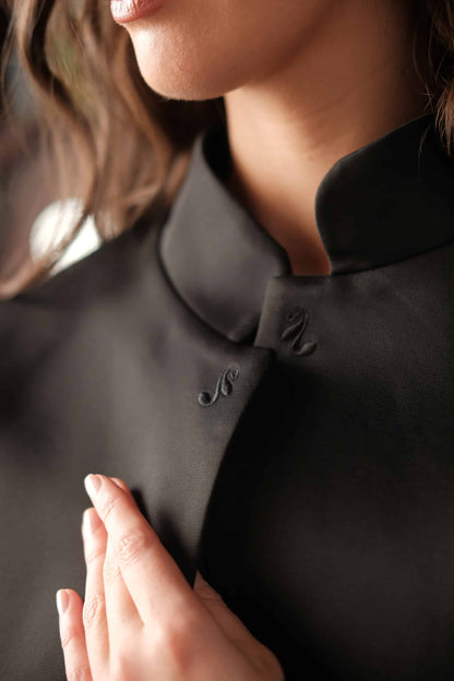 Close up detail of the Nights bolero jacket, showing the carefully embroidered logomark of the Sixth Langauge on the collar points. 