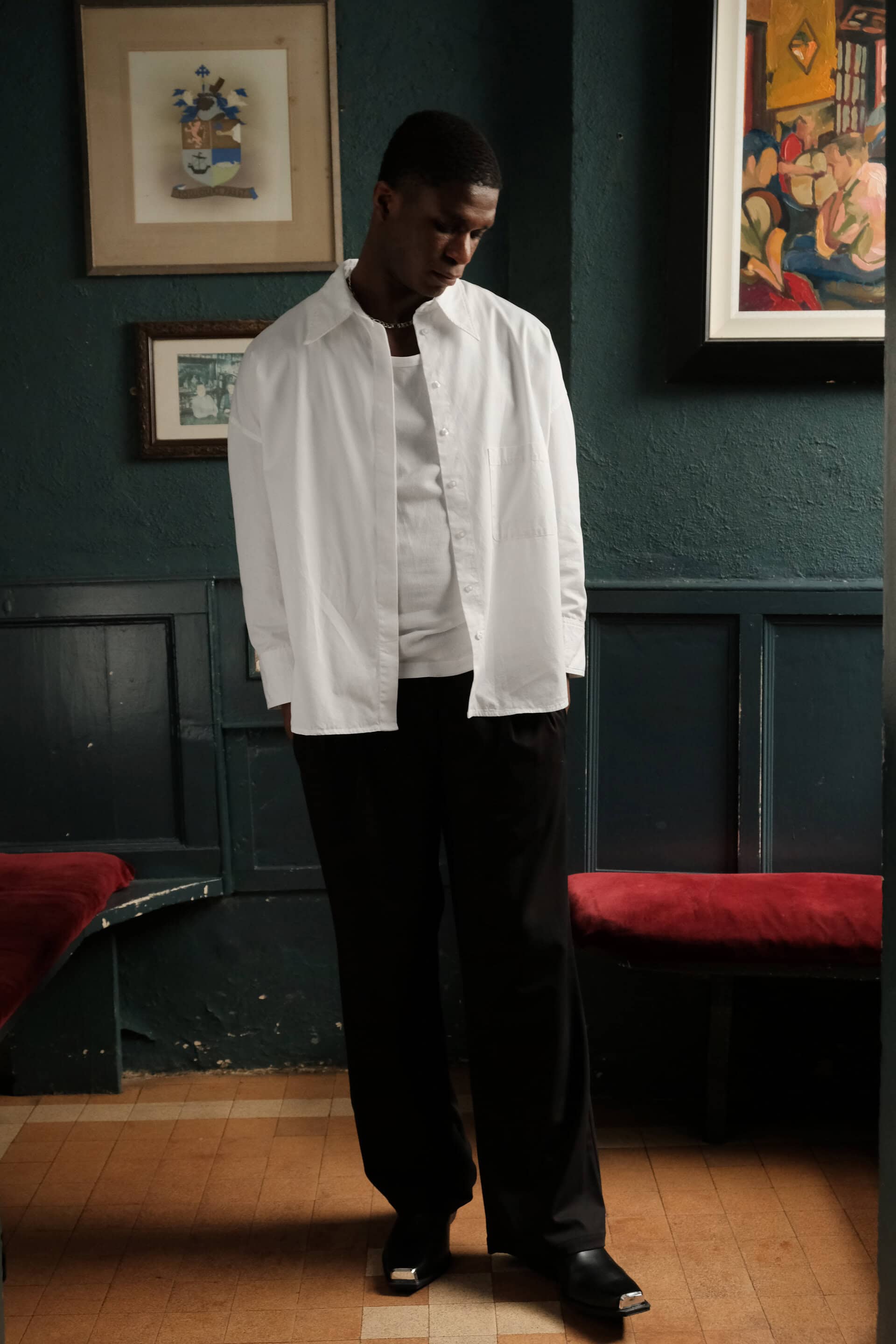 Full body shot of male model Patrick in a bar, wearing The Seasons Shirt and The Sonder Suit Trousers.