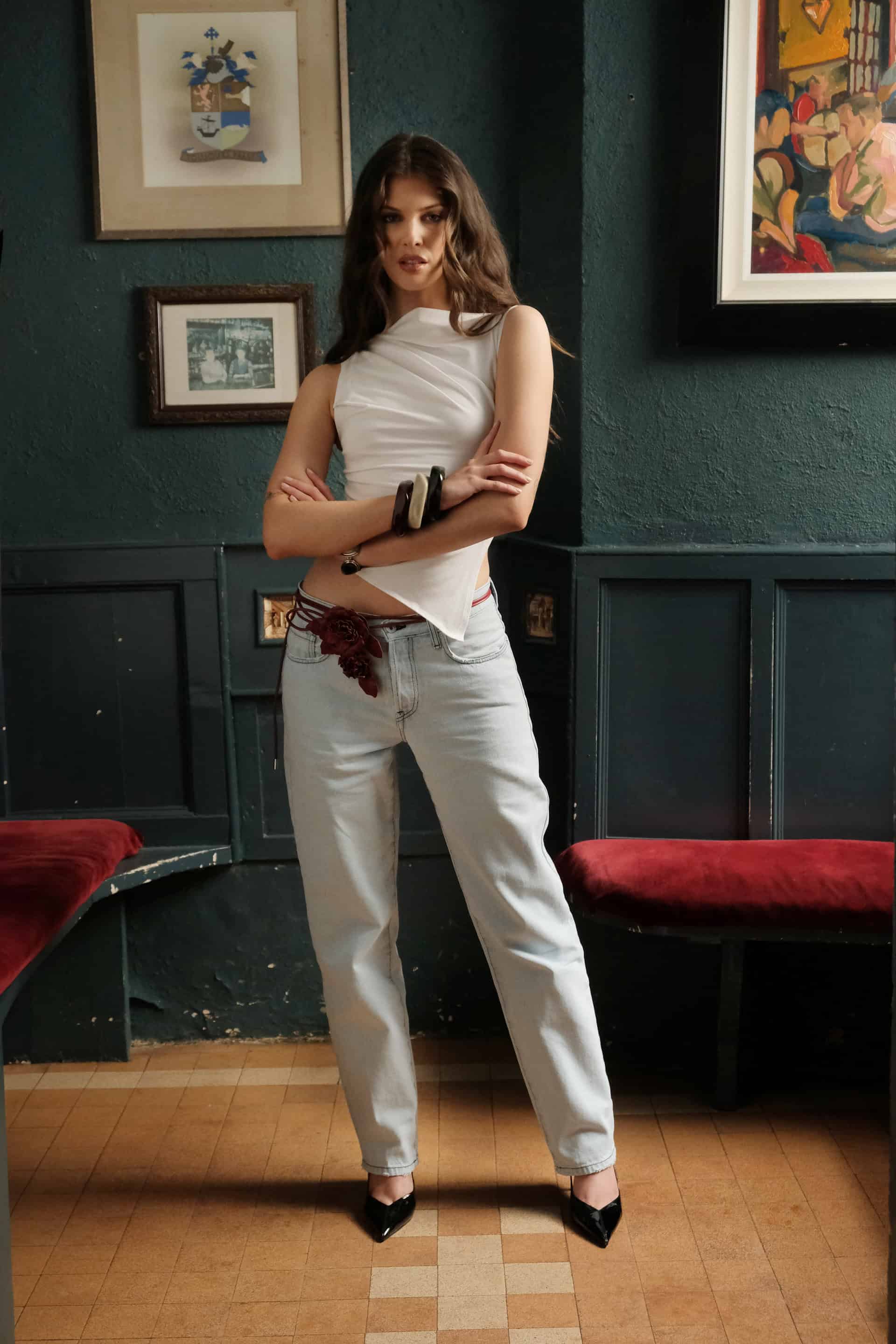 Female model Emma wearing statement pieces of The Sixth Language's debut collection "The Intro Collection": The backseat jeans, light blue stone wash and The Weekened Top, an asymmetrical fitted white top.