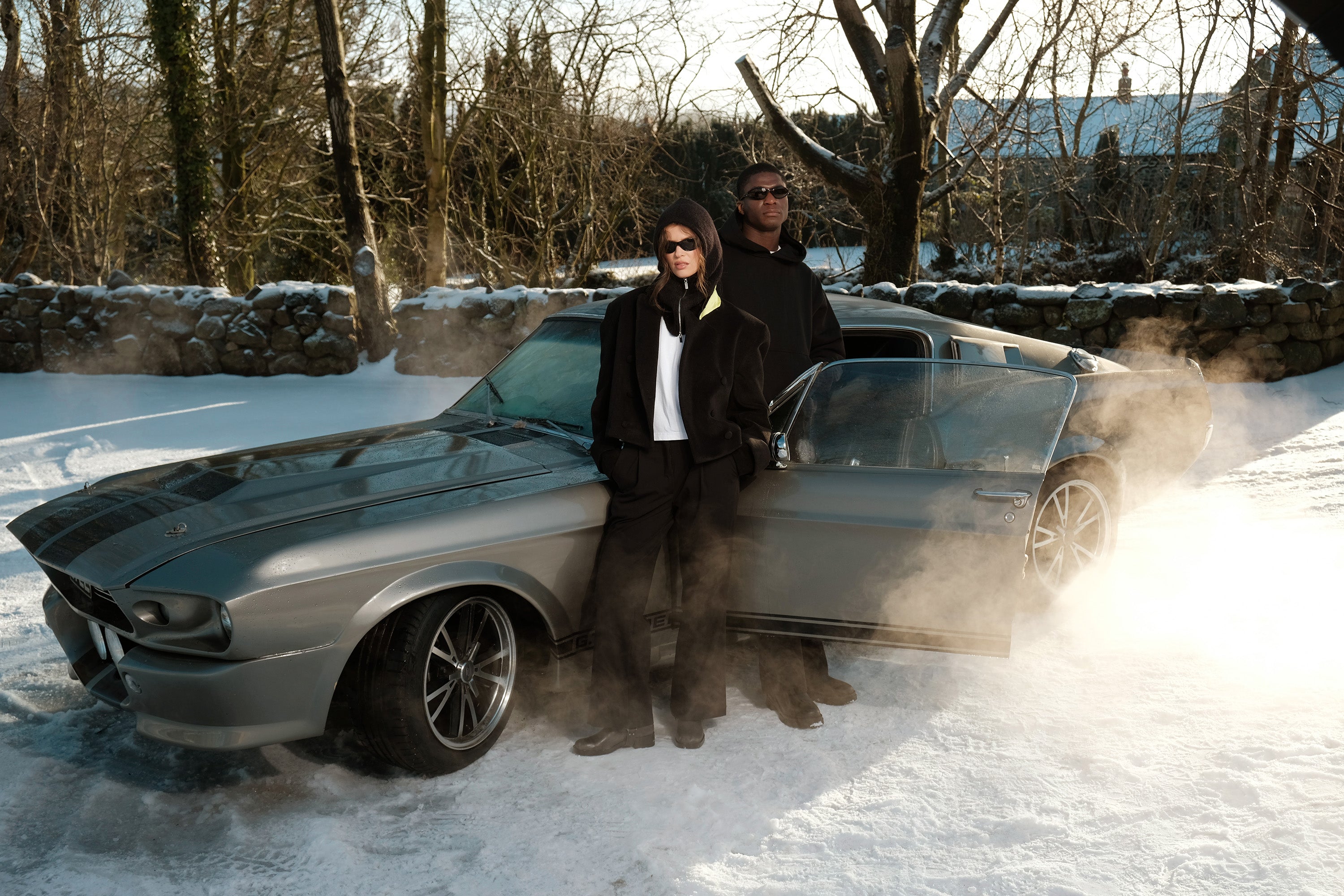 Emma and Patrick posed infront of a vintage ford Mustang, wearing The Evergreen Jacket, The Steal Hoodie and The Sonder Suit Trousers from The Sixth Language's debut collection "The Intro Collection"